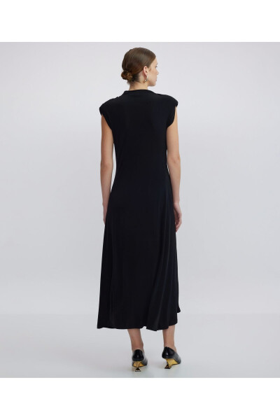 A high-necked, draped dress. - 12