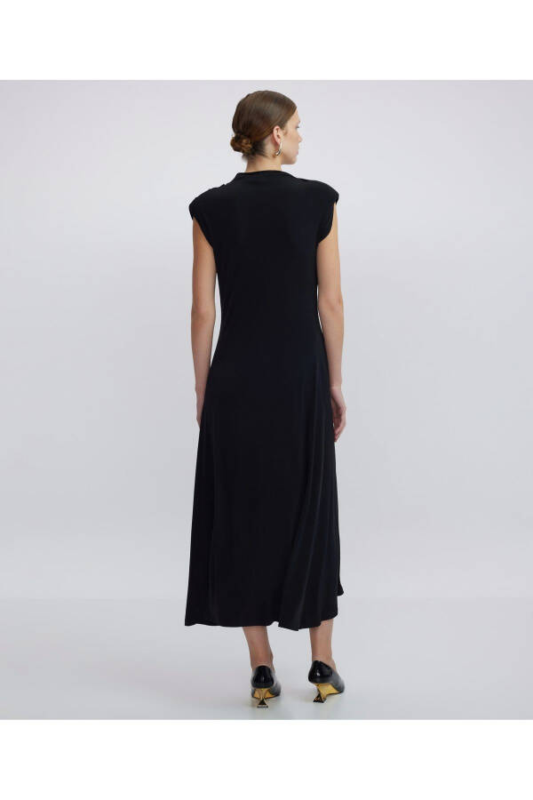 A high-necked, draped dress. - 6