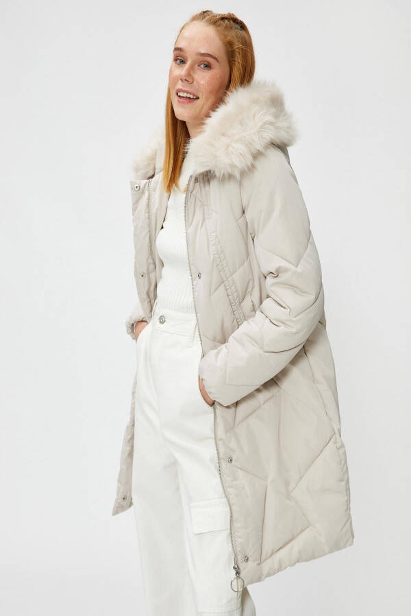 A woman wearing a white coat. - 2