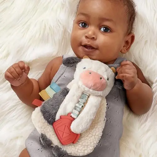 Itzy Ritzy - Itzy Lovey Including Teether - Baby Lovey with Teether, Textured Ribbons & Dangle Arms - Features Crinkle Sound, Sherpa Fabric and Minky Plush (Cow) - 3
