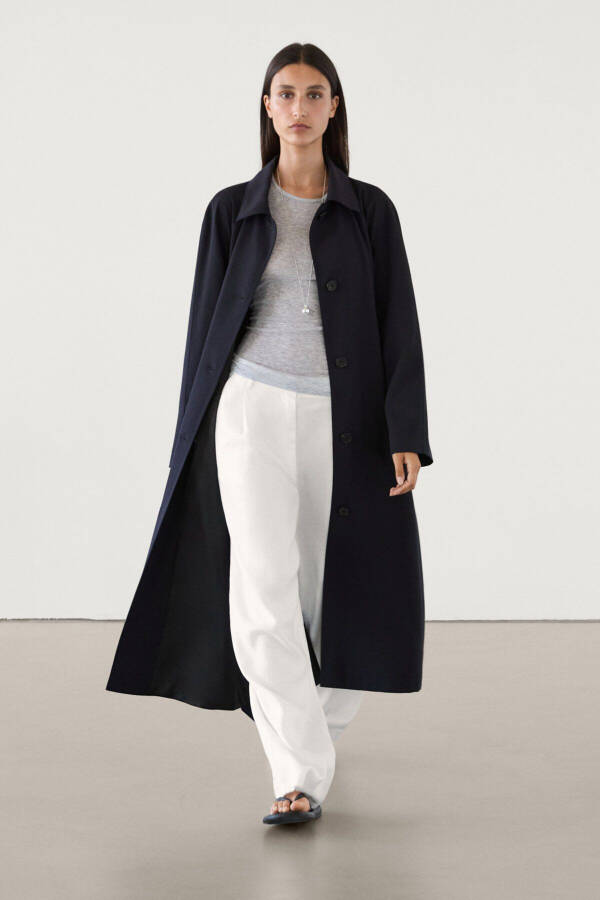 Navy trench coat with belt and pockets. - 1