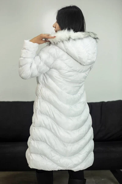 Она одета в длинное белое пальто. - 3