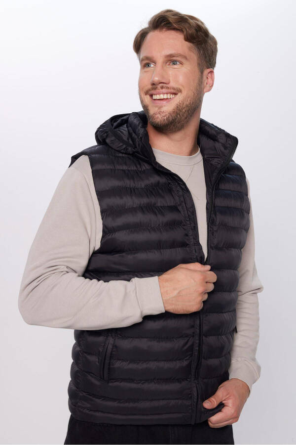 Slim fit, windproof, black puffer vest with detachable hood, pockets and lining. - 7