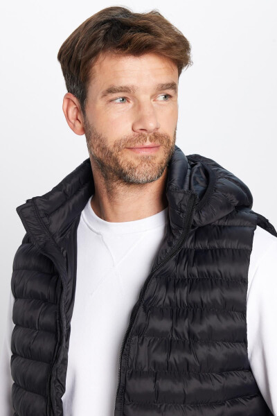 Slim fit, windproof, black puffer vest with detachable hood, pockets and lining. - 1