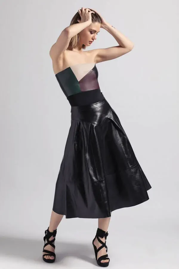 Uzun, qora, burmali, orqa tomondan fermuarli haqiqi teri yubka. - 2