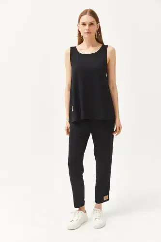 Woman in Black Sleeveless Baggy Blouse with Crystal Bottoms - OLALOOK (1)