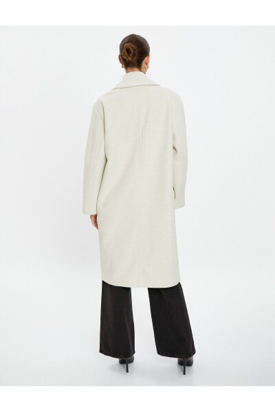 Wool coat with double-breasted closure and hidden pocket detail. - 11