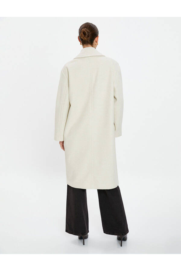 Wool coat with double-breasted closure and hidden pocket detail. - 11