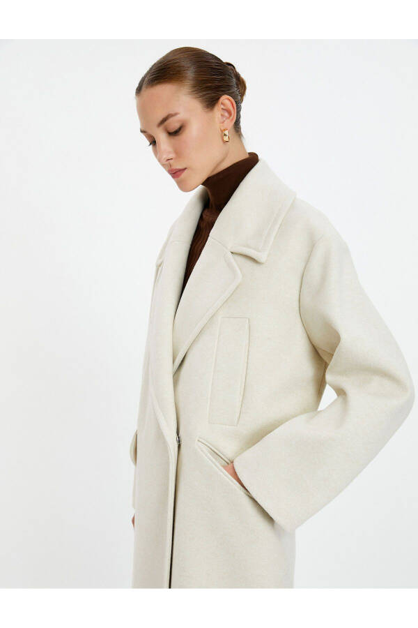 Wool coat with double-breasted closure and hidden pocket detail. - 1